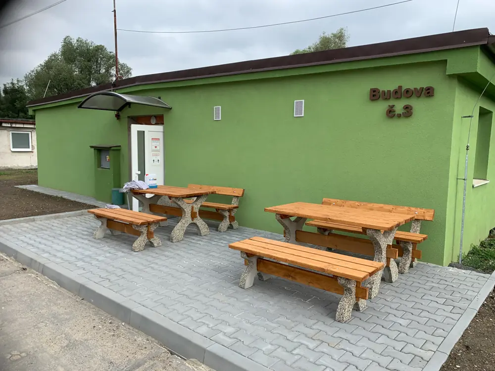 Будинок житла для працівників у Вратімові, біля входу столи й лавки